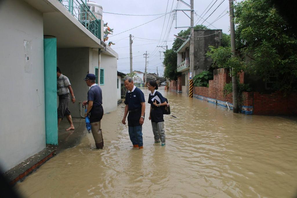 的乡亲度过难关[摄影者:沈美君] 图右 :由於大埤乡北镇村淹水未全退